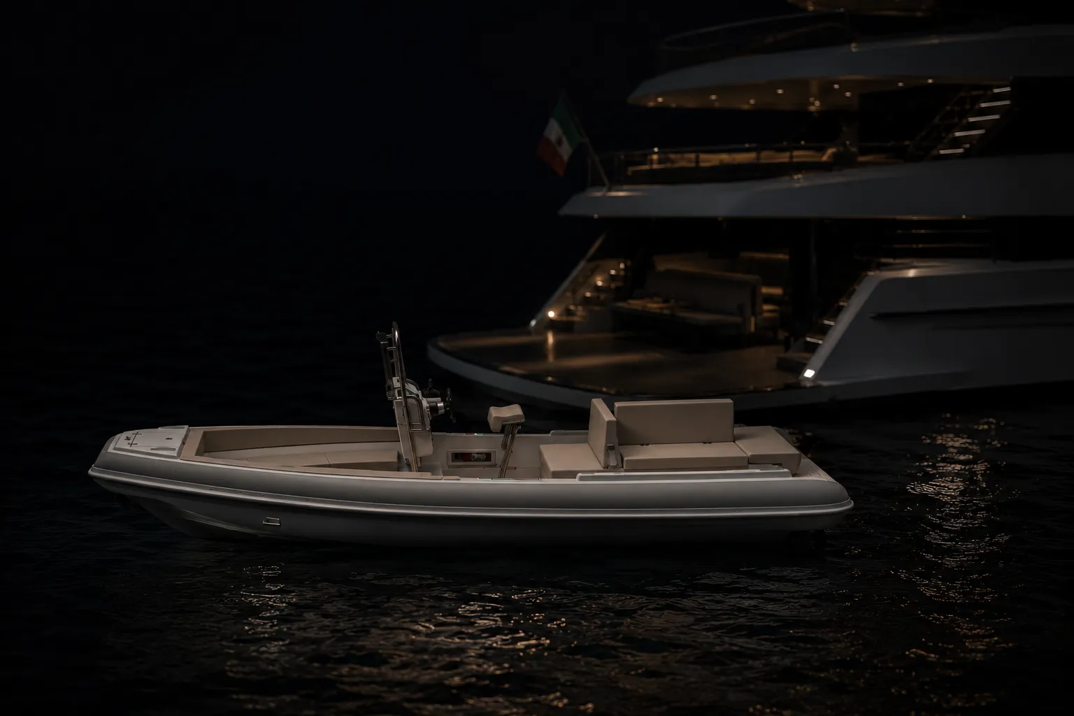 GARI Tender 700 ormeggiato di notte al fianco di uno yacht illuminato